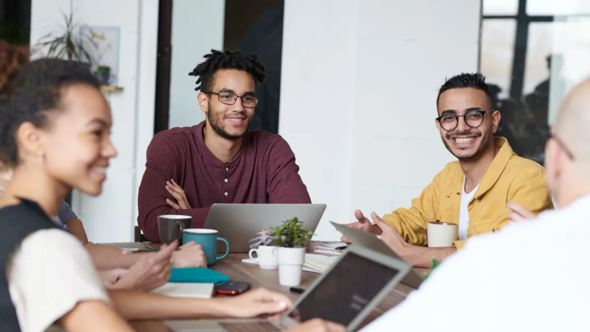 Photo of two young professional men sitting at a table in a meeting