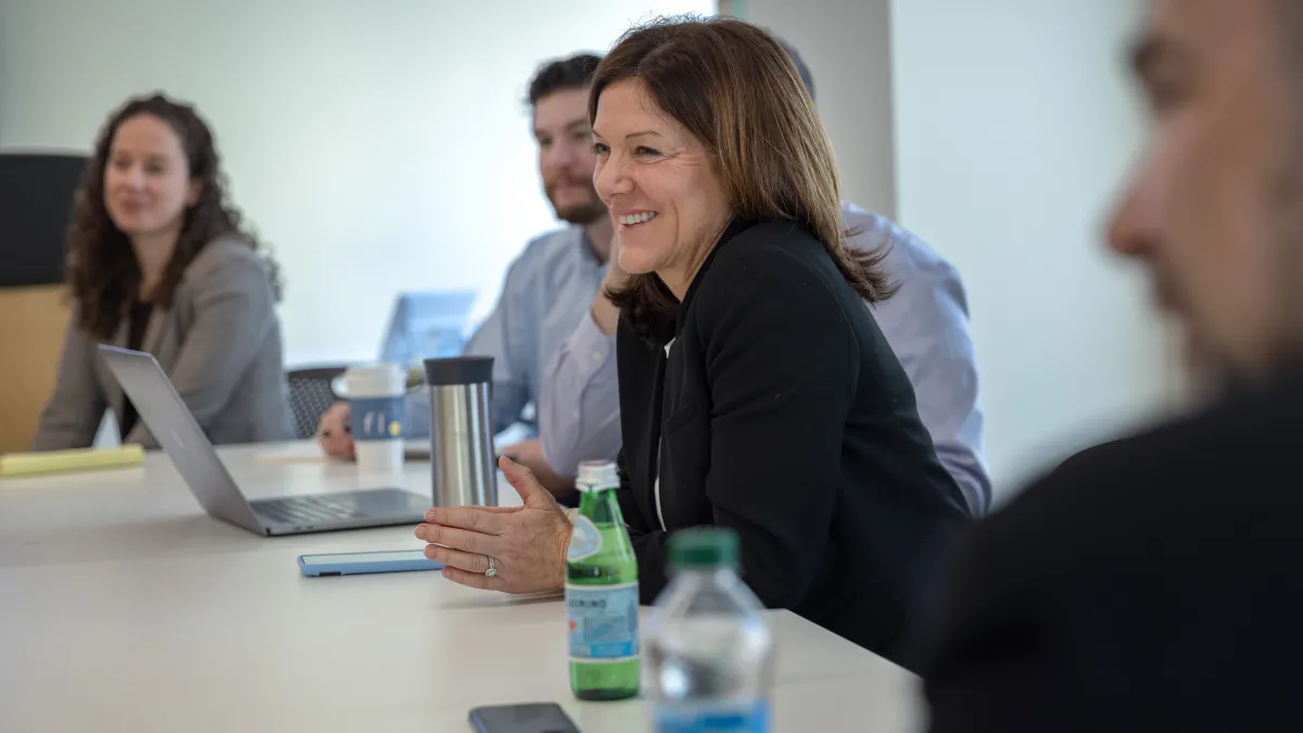 Photo of Catherine Breen in a meeting at a conference table.