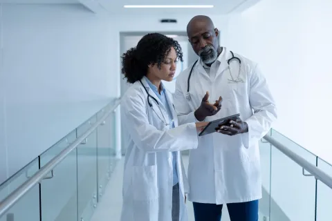 Two doctors talking with tablet