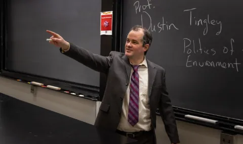 Photo of Professor Dustin Tingley in in front of a blackboard in a classroom