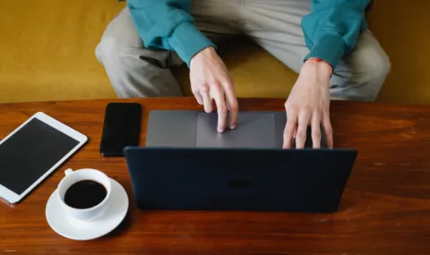 Image of laptop, phone, and table on a coffee table